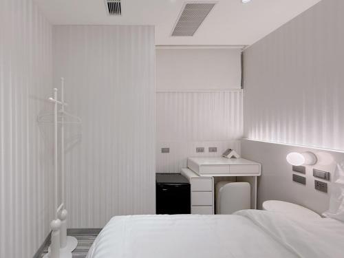 a white room with a bed and a sink at 在家行旅 南西館 in Taipei