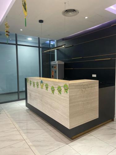 a lobby with a counter with green plants on it at The Luxe KLCC by Homestay in Kuala Lumpur