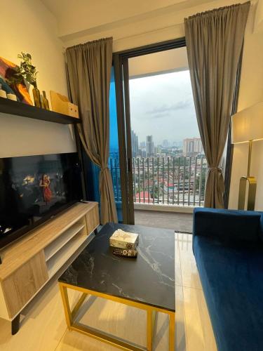 a living room with a table and a large window at The Luxe KLCC by Homestay in Kuala Lumpur