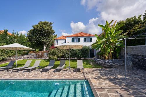 a villa with a swimming pool and a house at Bordal Houses in Funchal