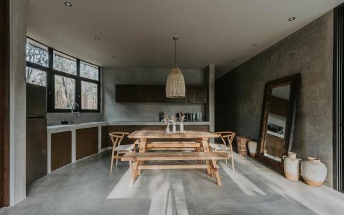 a dining room with a wooden table in a kitchen at Media Luna BoHo Chic Villa E11 Pvt Pool Concierge in Tulum