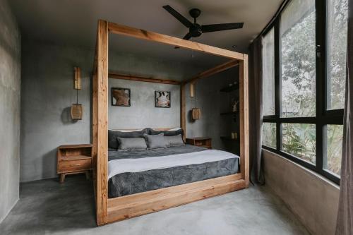 a bedroom with a bed with a large wooden frame at Media Luna BoHo Chic Villa E11 Pvt Pool Concierge in Tulum