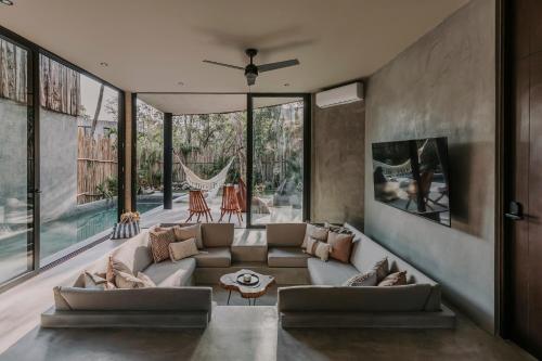 a living room with a couch and some windows at Media Luna BoHo Chic Villa E11 Pvt Pool Concierge in Tulum