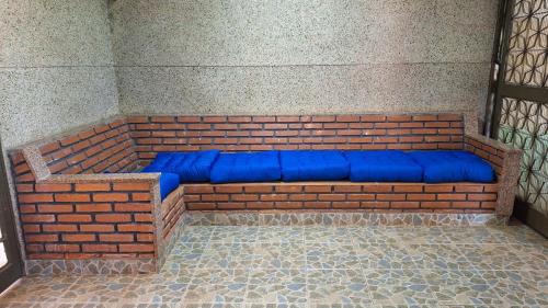 a brick bench with blue cushions on it at Casa Completa até 20 pessoas in Ribeirão Preto