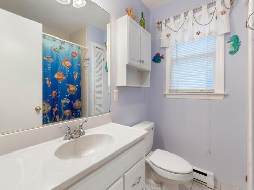 ein Badezimmer mit Waschbecken und Toilette und einem Fenster in der Unterkunft Wifi, Ourdoor Shower, Porch Ocean Side 1St Floor Duplex, A Short Walk From The Best Lbi Attractions, A Small Park, And The Beach, in Beach Haven
