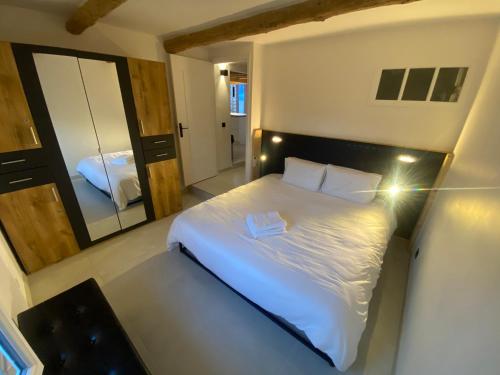 une chambre avec un lit blanc et un grand miroir dans l'établissement Appartement entièrement rénové à Saint-Aygulf, à Fréjus