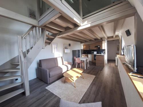 - un salon avec un escalier, un canapé et une table dans l'établissement Nid calme et cosy - Hypercentre avec superbe vue!, à Besançon