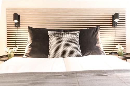 a bed with two pillows and a head board at INN JOY Apartments - Sankt Gallen Town Apartment in St. Gallen