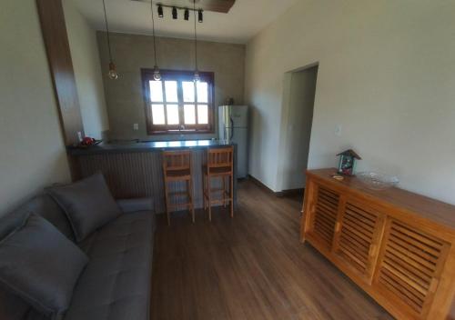 a living room with a couch and a kitchen at Chalés da Marisa - Serra da Canastra in São João Batista do Glória