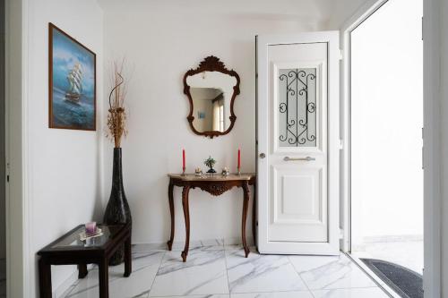 a room with a door and a table and a mirror at Rumi's Paros house in the heart of Parikia in Parikia