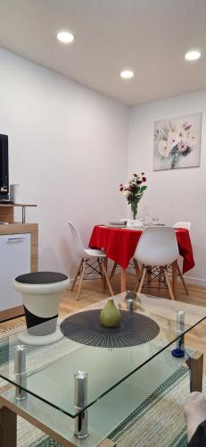 a living room with a glass table and a dining room at Vytauto Centriniai apartamentai in Šiauliai