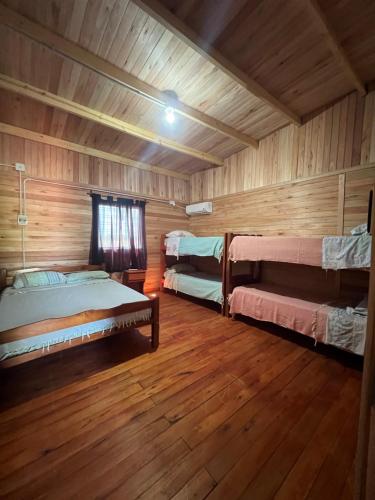 a room with two beds in a wooden cabin at Mar de Sueños - Complejo Turístico y Parque Acuático in Paraná