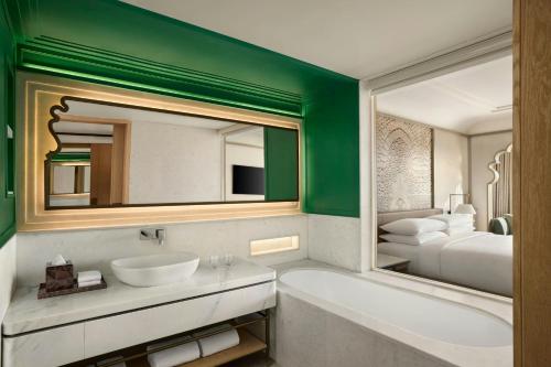 a bathroom with a tub and a sink and a mirror at Udaipur Marriott Hotel in Udaipur