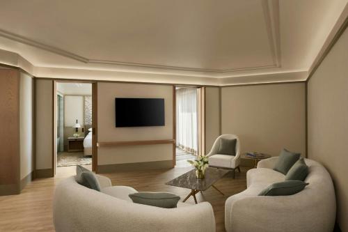 a living room with two couches and a tv at Udaipur Marriott Hotel in Udaipur