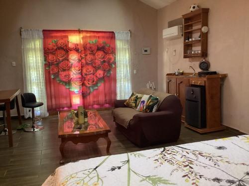a living room with a couch and a red curtain with roses at cabin Claro luna orchard, swimming pool 70mbps wifi in La Esperanza