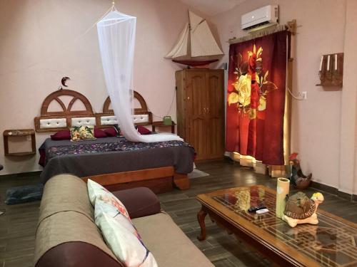 a bedroom with a bed and a couch and a table at cabin Claro luna orchard, swimming pool 70mbps wifi in La Esperanza