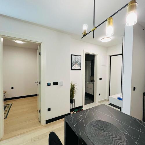 a living room with a table and a hallway with two doors at Apartman1105 Sarajevo Free Garage in Sarajevo