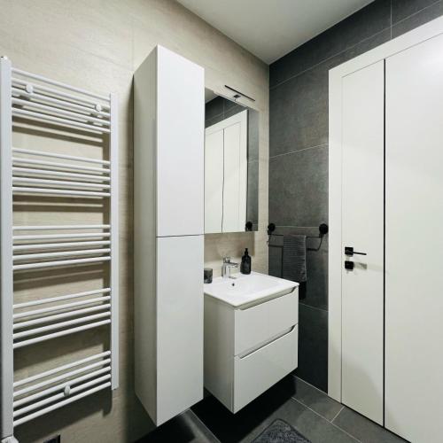 a bathroom with a white sink and a shower at Apartman1105 Sarajevo Free Garage in Sarajevo