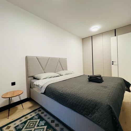 a bedroom with a large bed and a table at Apartman1105 Sarajevo Free Garage in Sarajevo