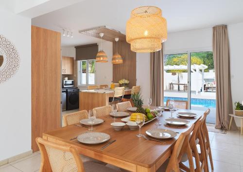 a dining room and living room with a wooden table at LuxVillasRentals Ayia Napa in Ayia Napa