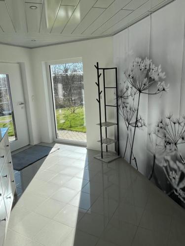 a white room with a shelf and flowers on the wall at Großzügige Ferienwohnung in Laubach