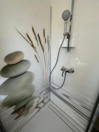 a bathroom with a shower with rocks and a mirror at Großzügige Ferienwohnung in Laubach