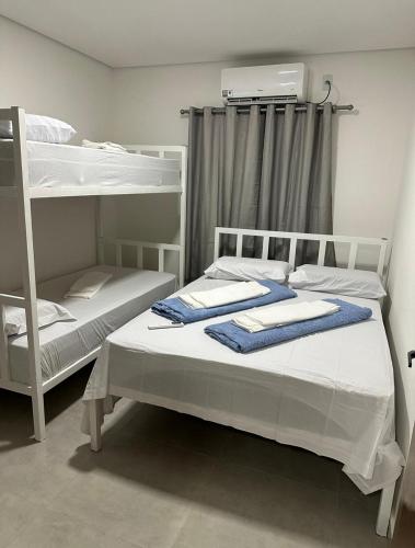 a bedroom with two bunk beds with towels on them at Hotel Paraiso Go in Valparaíso de Goiás