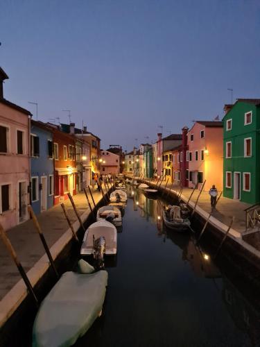 a group of boats docked in a canal with buildings at Ca' Nova - Burano in Burano