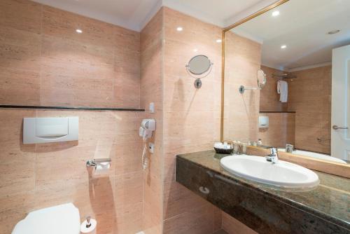 een badkamer met een wastafel en een spiegel bij Botel Alcudiamar in Port d'Alcudia