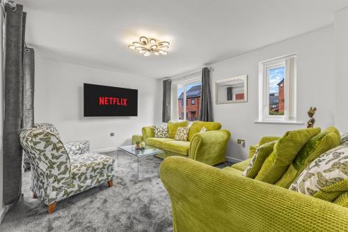 a living room with yellow chairs and a tv at Large Family House with free parking - 3 bedrooms 6 beds in Manchester