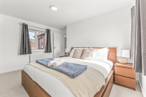 a bedroom with a large white bed with a window at Large Family House with free parking - 3 bedrooms 6 beds in Manchester