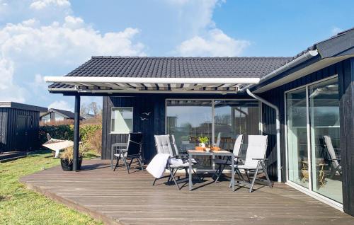 a wooden deck with a table and chairs on it at 3 Bedroom Nice Home In Haarby in Hårby