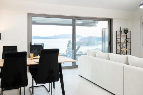 a living room with a white couch and a table and chairs at Villa Scorpios View in Nydri