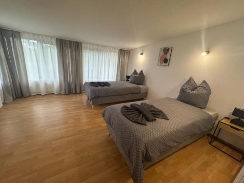a hotel room with two beds and wooden floors at PS Apartments Freienhufen in Großräschen