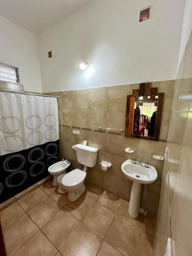 a bathroom with a sink and a toilet and a mirror at Departamentos La Morita in Embalse