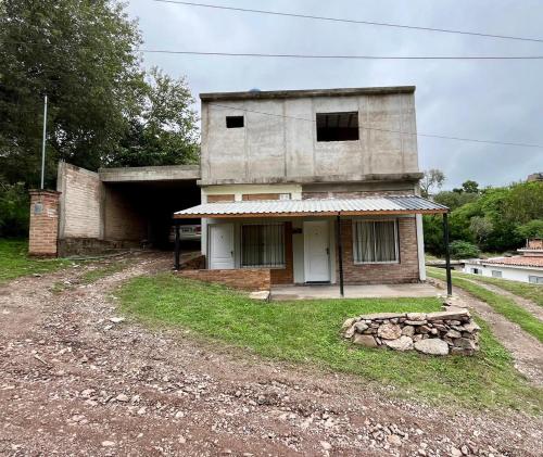 an old house on the side of a dirt road at Departamentos La Morita in Embalse