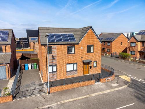a brick house with solar panels on it at Large Family House with free parking - 3 bedrooms 6 beds in Manchester