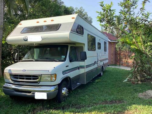 an rv parked in the grass next to a fence at Susurro de estrellas in La Esperanza