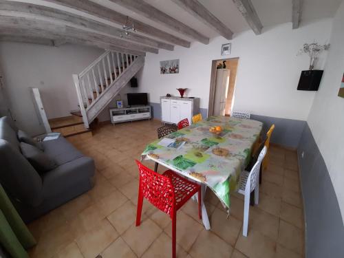 un salon avec une table et des chaises et un escalier dans l'établissement Maison Joséphine, à Valras-Plage