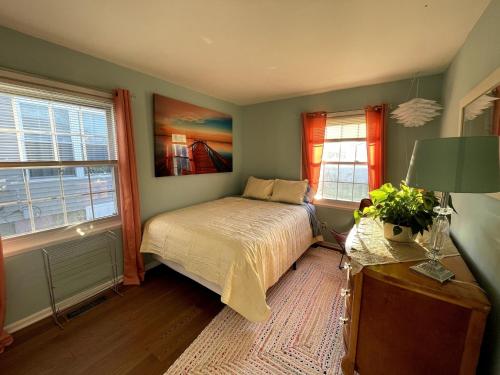 une chambre avec un lit et deux fenêtres dans l'établissement Blue Betty- 3 BDRM Mid-Century Charmer Near Beach, à Brigantine