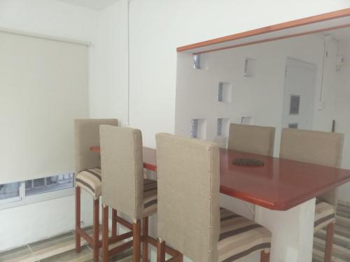a dining room with a wooden table and chairs at Casa amoblada eventual in Villa Mercedes
