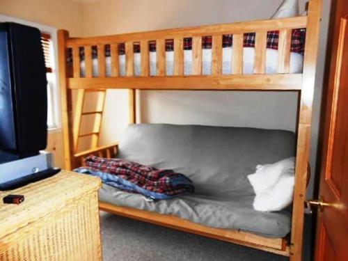 a bunk bed with a couch in front of a television at Beach Haven Single Family Oceanside Beach Badges Wifi in Beach Haven