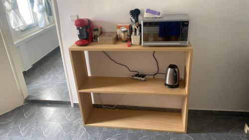 a shelf with a microwave on top of it at Appartement Moderne Centre ville BZV in Brazzaville