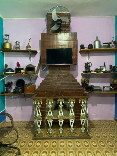 a living room with a fireplace and a television at Pousada Chiclé Penedo MC in Penedo