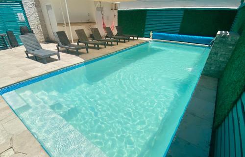 a large blue swimming pool with chairs in it at FRENTE PLAYA vista al mar, PISCINA DE USO EXCLUSIVO in Boca del Río