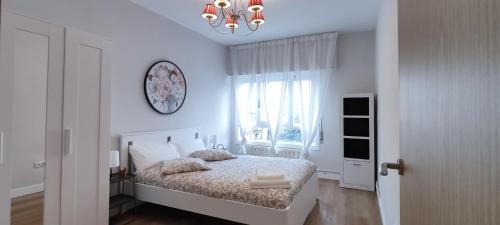 a white bedroom with a bed and a window at Céntrico espacioso y muy luminoso in Villasana de Mena