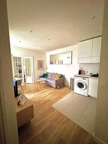 un salon avec un canapé et une cuisine dans l'établissement Modern & Central Apartment, à Paris