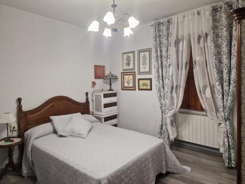 a bedroom with a bed and a window at Piso vacacional en Casa Carroucha in Valga