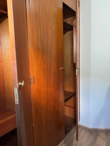 a closet with a wooden door in a room at Quartos para alugar em itu Hostel Jm in Itu