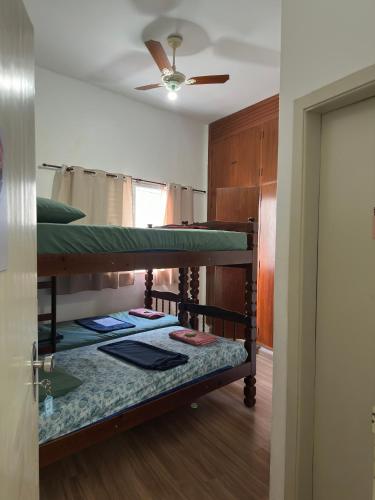 two bunk beds in a room with a ceiling fan at Quartos para alugar em itu Hostel Jm in Itu